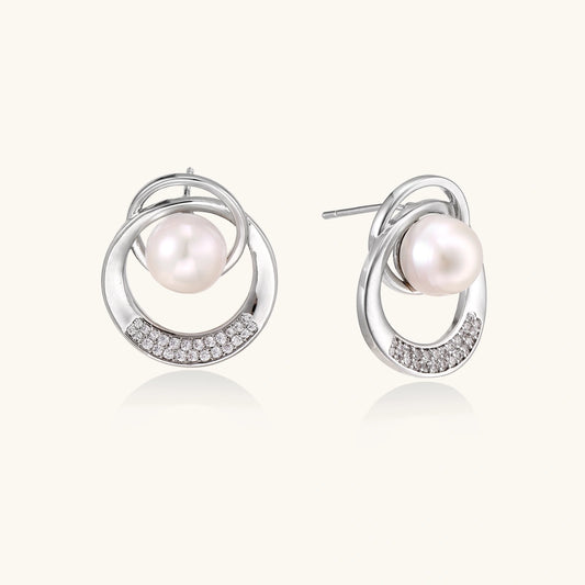 White gold-plated brass earrings with circular design, freshwater pearl center, and diamond accents